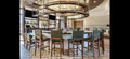 Dining area with a large round chandelier, table, and chairs in a modern interior setting.