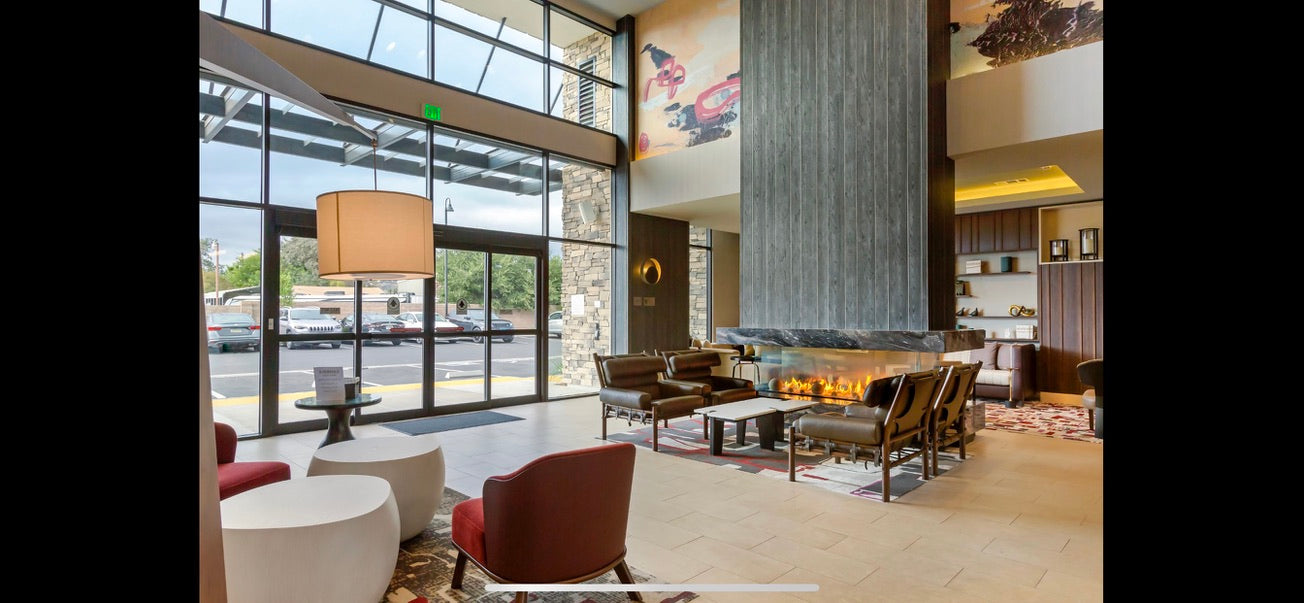 Modern interior of a building with a fireplace and large windows.
