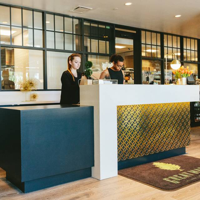 Two people behind a modern reception desk in a stylish interior setting.