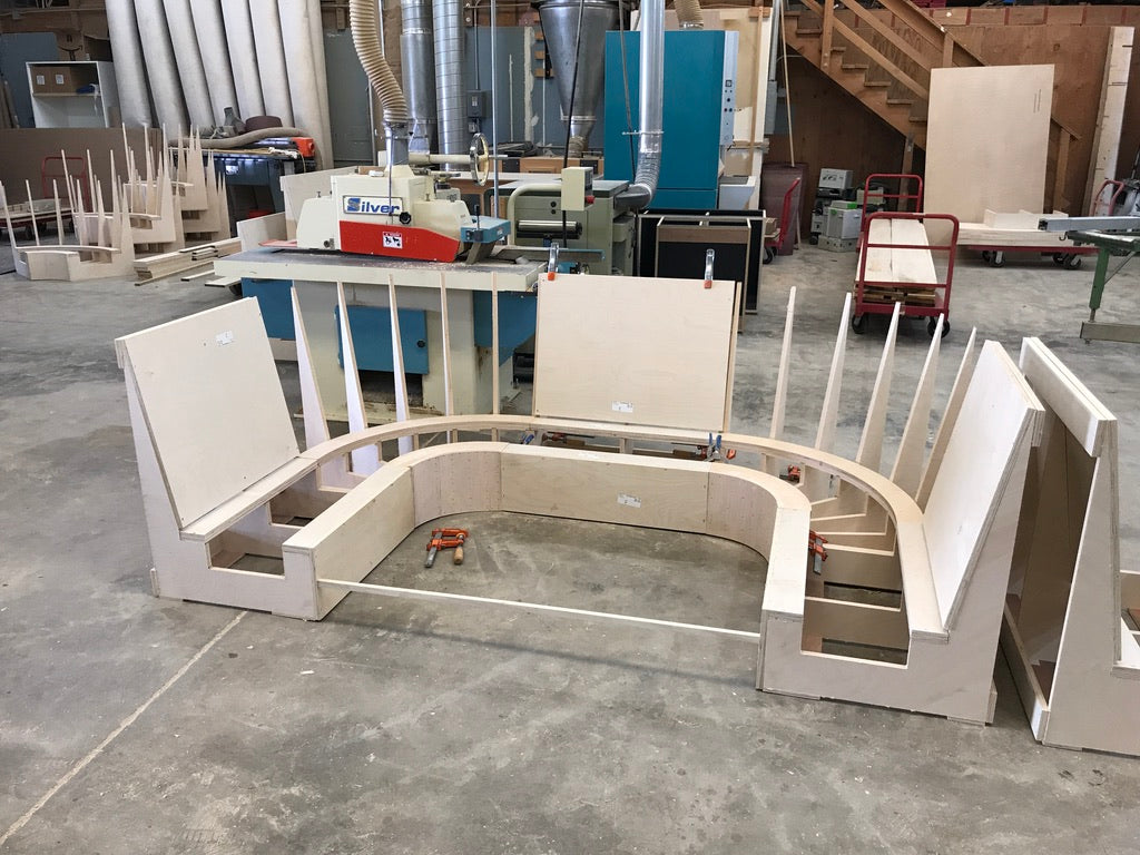 Unfinished circular wooden bench in a workshop setting