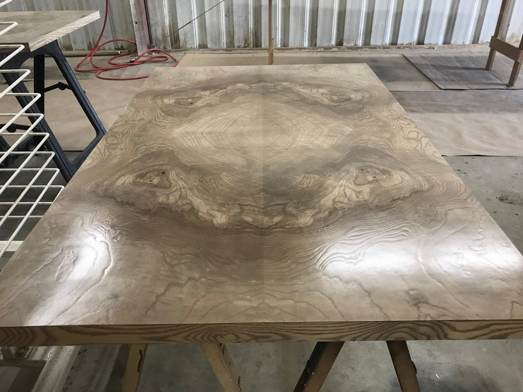 Wooden table with a marbled finish in a workshop setting