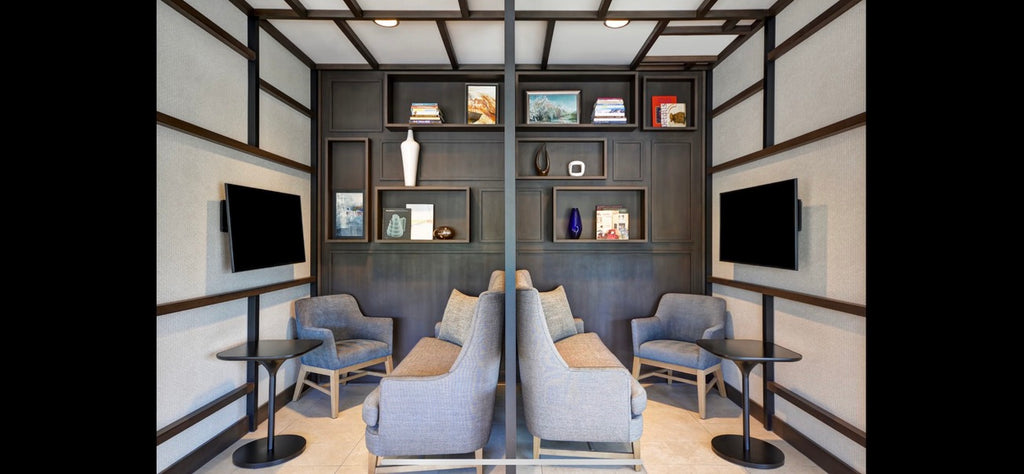 Modern living room with gray sofas, coffee tables, and wall-mounted televisions.