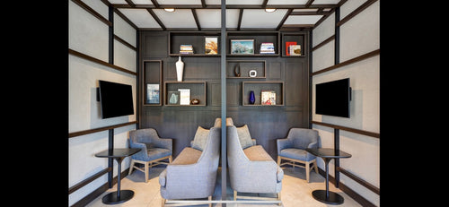 Modern living room with gray sofas, coffee tables, and wall-mounted televisions.