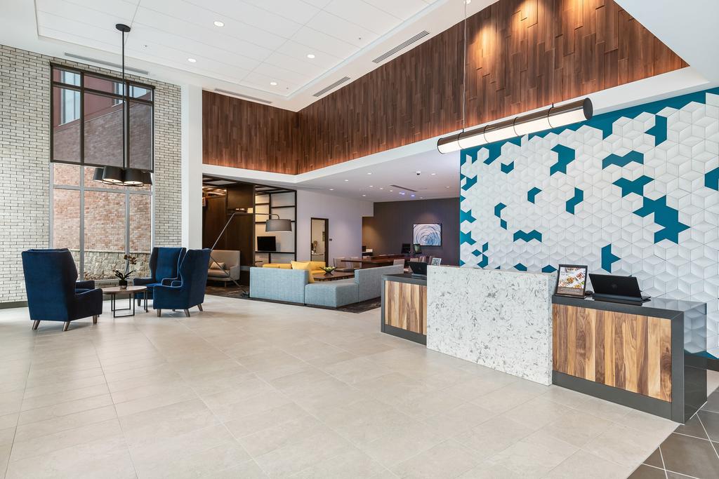 Modern lobby with reception desk, seating area, and decorative wall art.