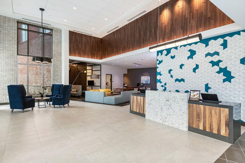 Modern lobby with reception desk, seating area, and decorative wall art.