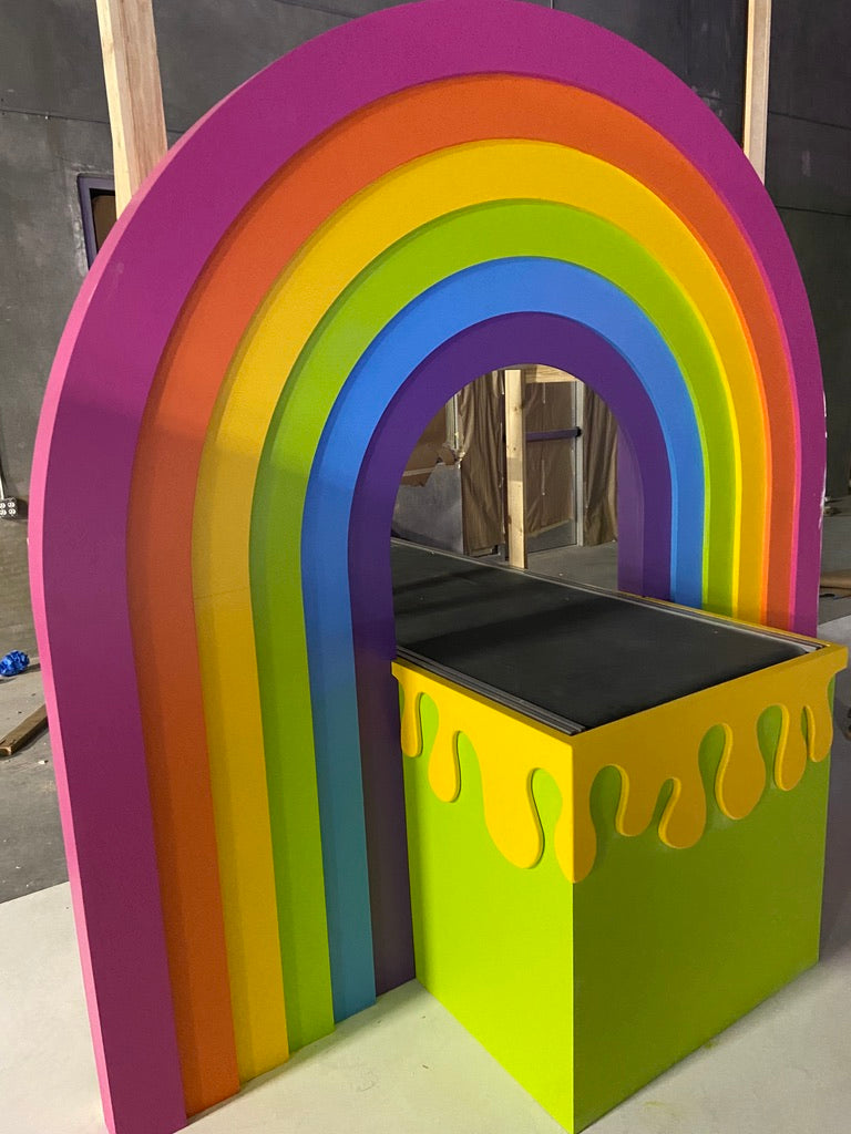 Colorful rainbow-shaped playhouse with a black top and yellow base.